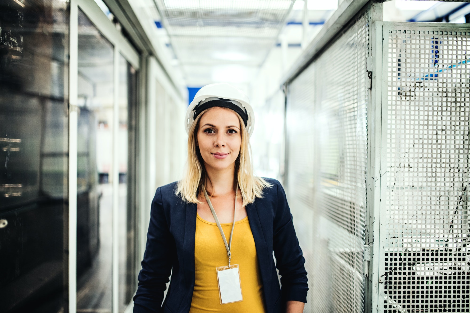 A portrait of an industrial woman engineer standing in a factory.
